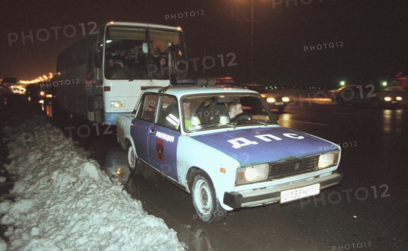 Moscow, russia, november 15 2002: tajik illegal immigrants in a bus escorted by a police car (in pic) on their way to chkalovsky airport for further deportation, the people's courts of khimki and podolsk districts took the decisions on the deportation of a group of tajik immigrants staying in moscow region without valid documents.