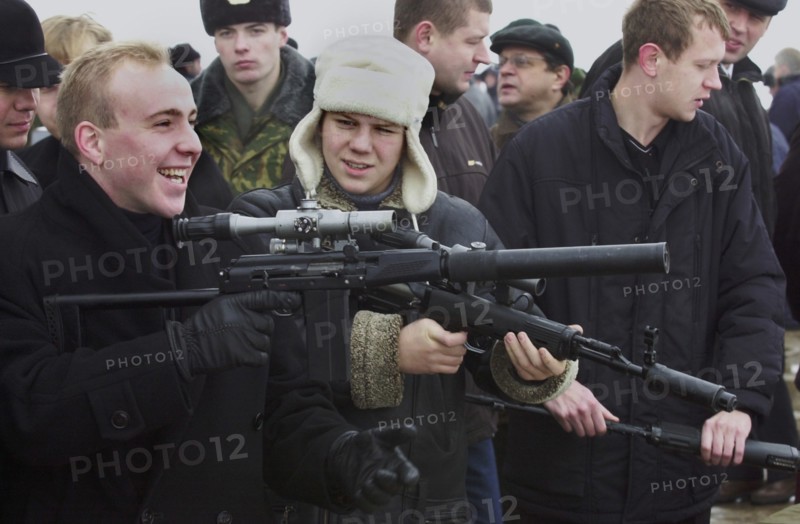 Moscow region, russia, november 15 2002: visitors to the exhibition familiarizing themselves with new samples of modern small arms of foreign and home production at a shooting ground in balashikha near moscow, on friday, the demonstration was held by servicemen of russian ministry's special task force within the framework of the 6th international state security forum interpolitex - 2002, (photo alexander yakovlev).