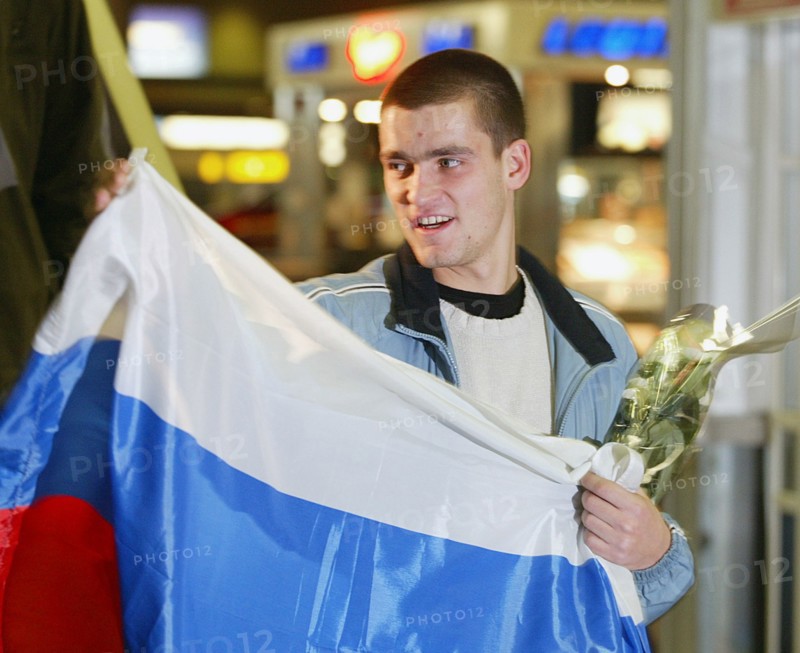 Moscow, russia, december 3 2002: russian tennis player mikhail youzhny, who scored the decisive point and brought the win of the davis cup to the russian team , pictured with a russian flag at the sheremetyevo airport, as he returned to moscow on monday evening, (photo itar-tass/vitaly belousov).