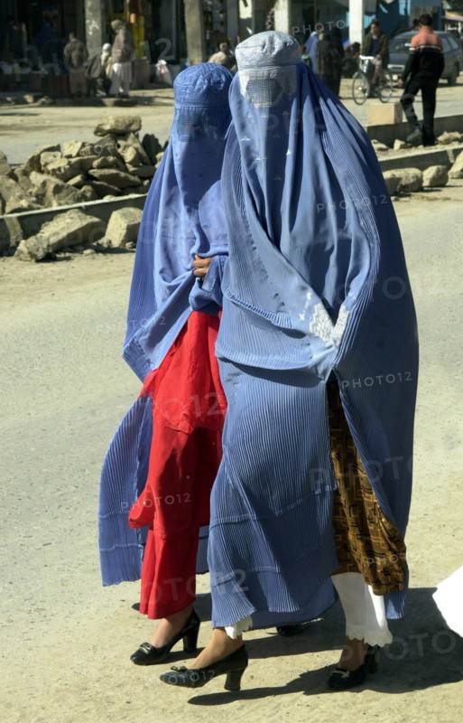 Afghanistan, march, 7 2003, afghani women wearing burkas, traditional capes with veils hiding the person, try to look attractively: from under the cape clothes corresponding to a local fashion and footwear are always visible, a photo sergey zhukova   .