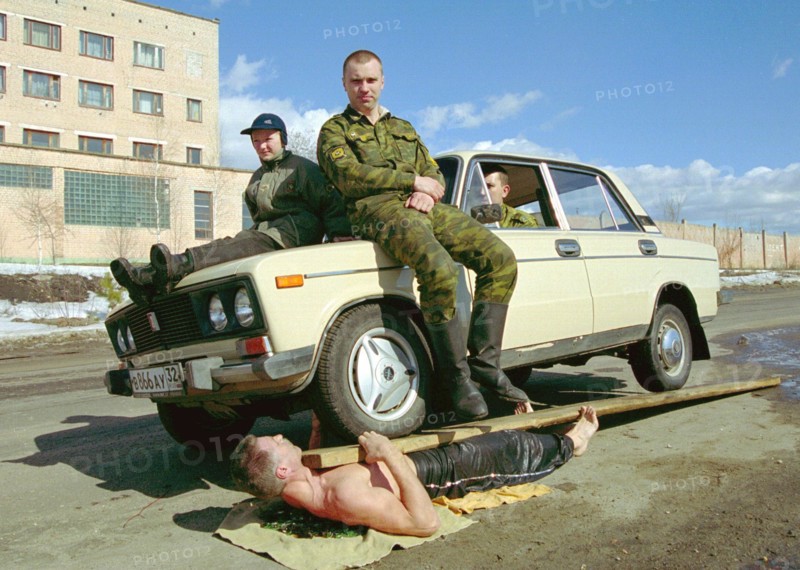 Physical endurance: firefighters, bryansk, russia, march 27 2003, captain of the russian interior ministry forces, guard commander of a bryansk fighfighters' unit mikhail karpeshin (bottom) demonstrates his unique physical abilities, lying on broken glass and holding a car with three men on his chest, karpeshin formerly worked as circus performer, (photo itar-tass/vladimir gorovykh)  .