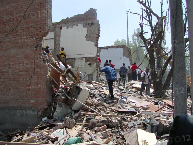 Chechnya, russia, may 12, 2003, people pictured clearing the debris in the village of znamenskoye where a powerful explosion ruined the buildings that housed the district administration ,on monday , many people were killed and injured in the terrorist act.