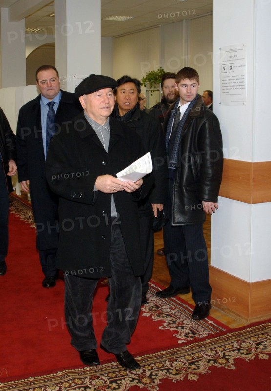 Moscow mayor yuri luzhkov (front) and his press secretary sergei tsoi (background c) arrive at a polling station during moscow city duma elections, moscow, russia, december 4, 2005.
