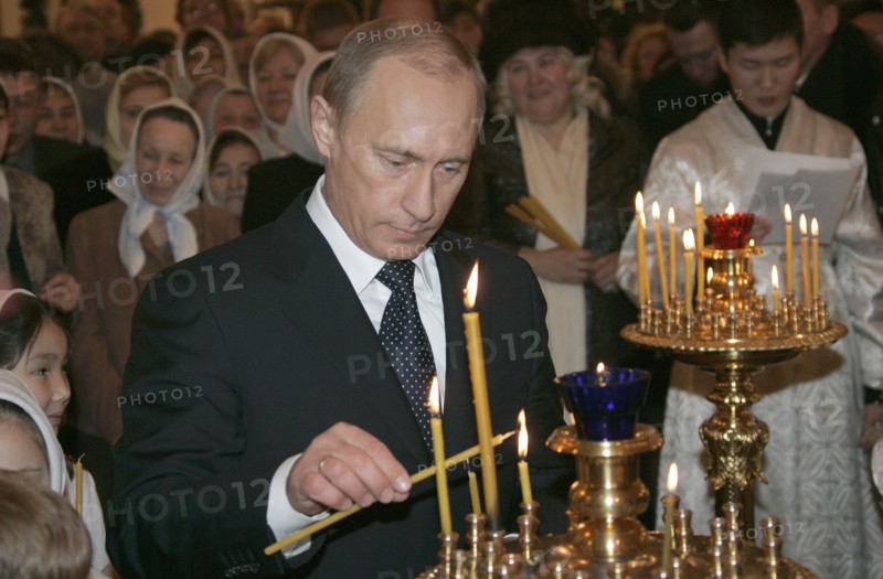 Russian president vladimir putin lights a candle during russian orthodox christmas celebrations on the eve of the holiday friday in a cathedral in the siberian city of yakutsk, orthodox christians use the old julian calendar and mark christmas on jan, 7, 2006.