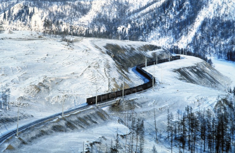 A freight train traveling along the trans-siberian railway through a snowy landscape in winter, siberia, russia.