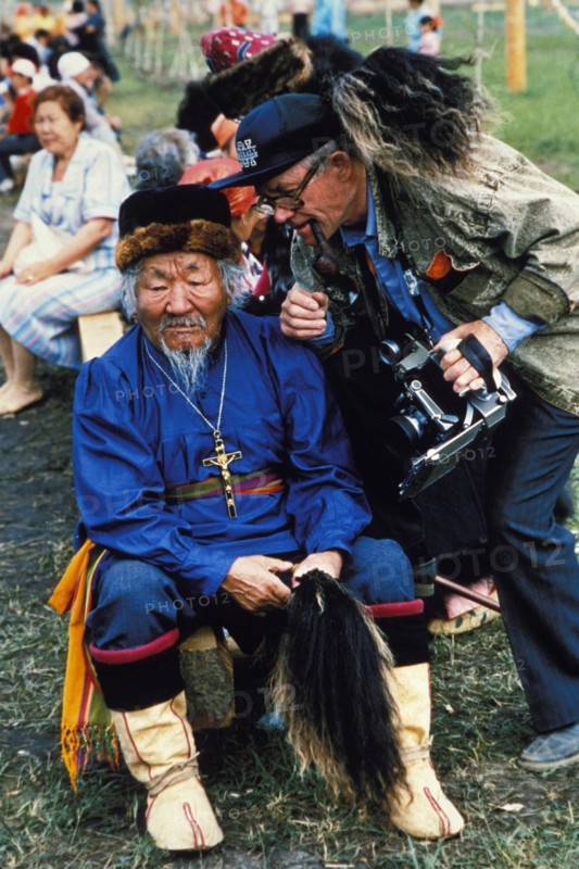 A folk performer and a photographer during the yakut folk festival, 'ysyakh', siberia, russia.