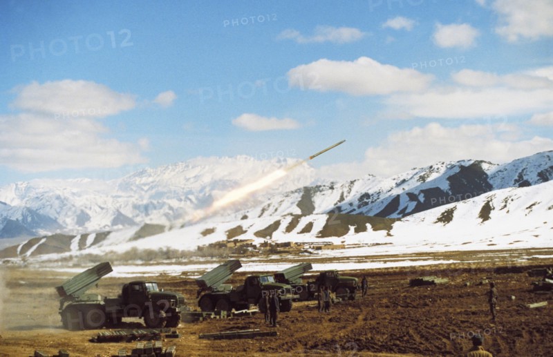 Afghan government troops attacking mujahadeen-held village of mohammed aga with soviet-made rocket launchers, abbazak mtn, pass, afghanistan, march, 1990.