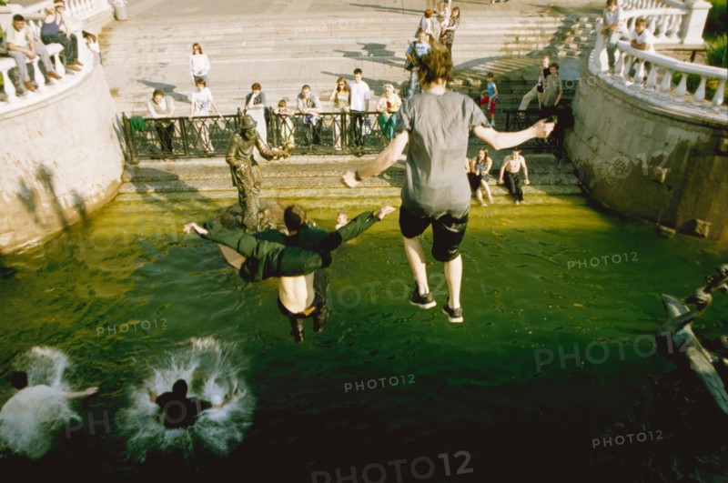 Young people swimming in the fountain in manege square to cool off from the heat, moscow, russia, july 2003.