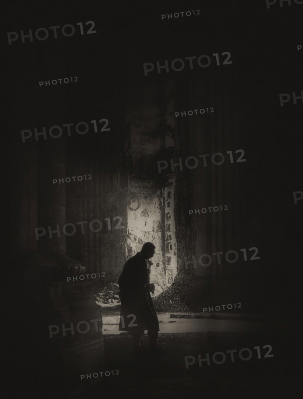 A magic lantern slide shows a silhouetted man stands inside the Cathedral of Reims after the shelling by German troops in 1914; Reims