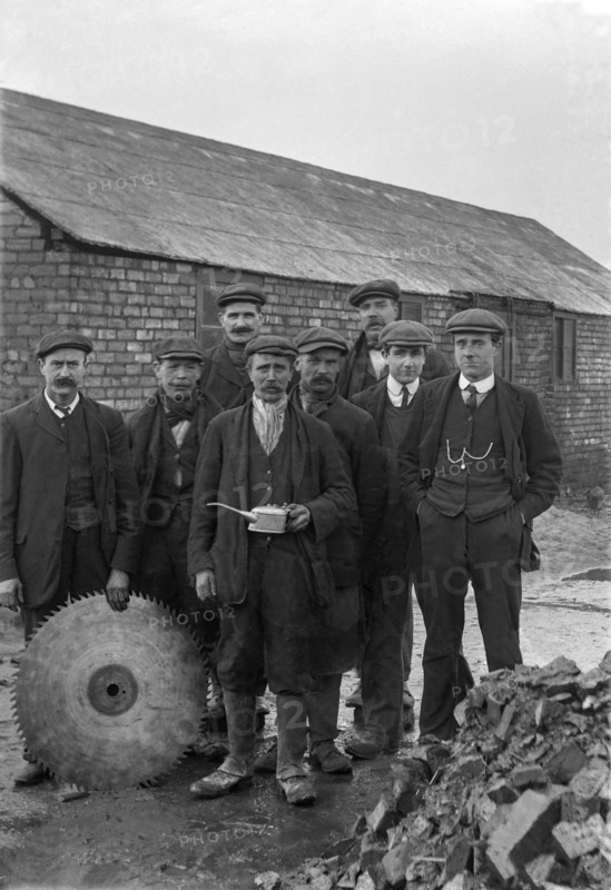 A historical image of a group of men standing together in suits and hats