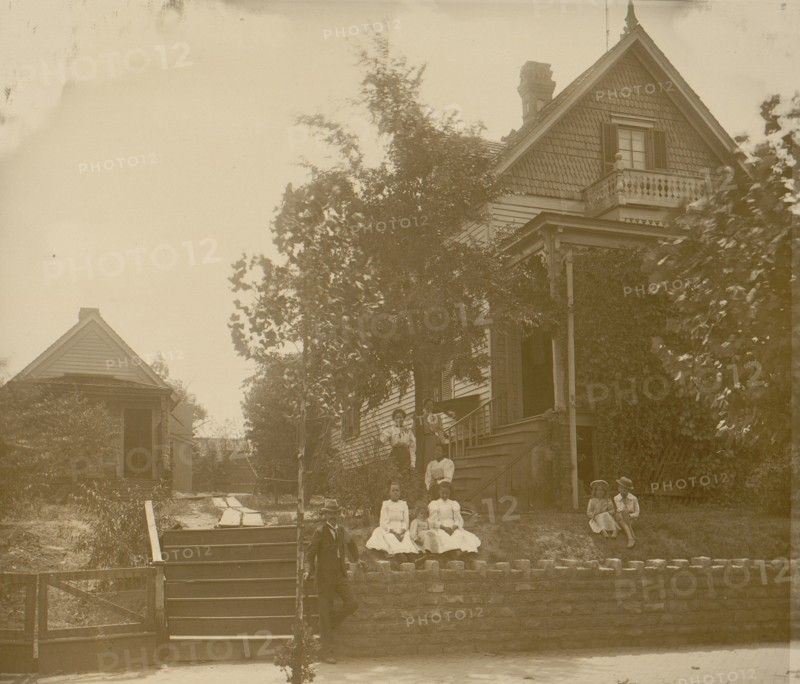 African American family posed on porch of house