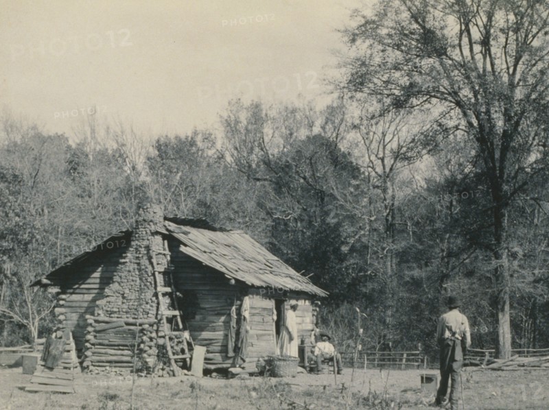 Three African Americans outside a cabin, possibly Mt. Meigs, Alabama