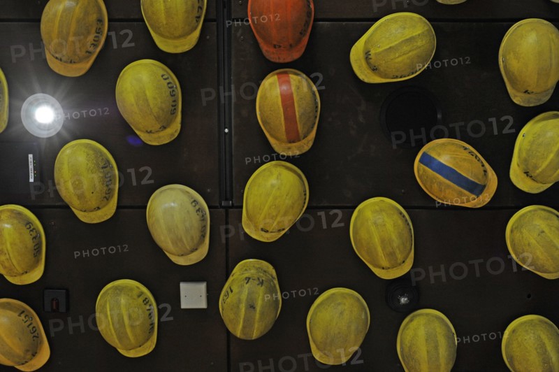 Workers helmets hanging from the ceiling.