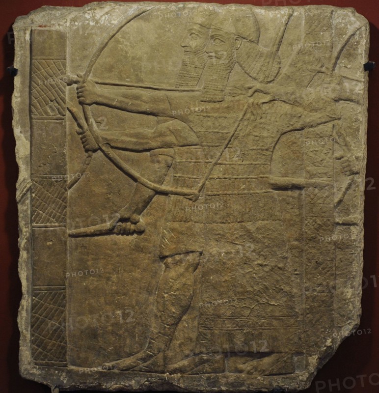 Assyrian warriors attacking an enemy city.