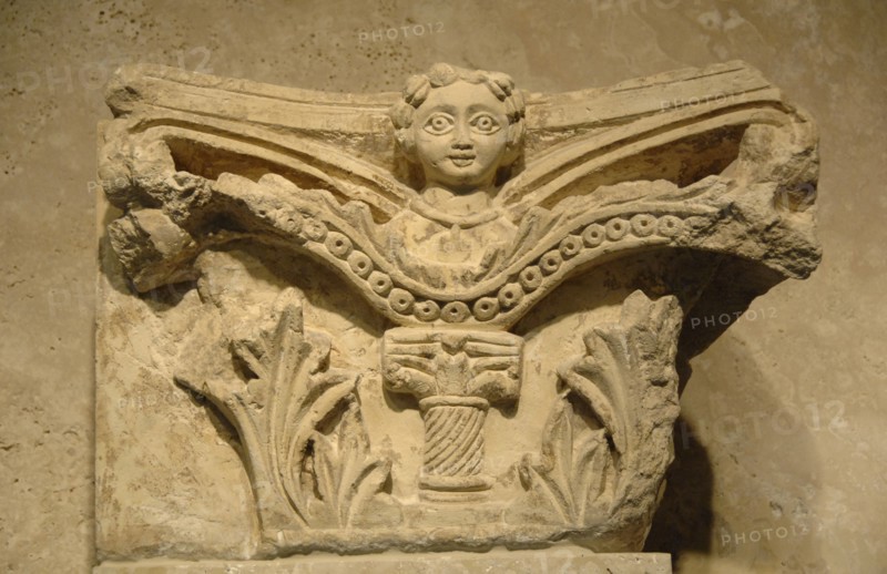 Capital decorated with a relief of a woman.