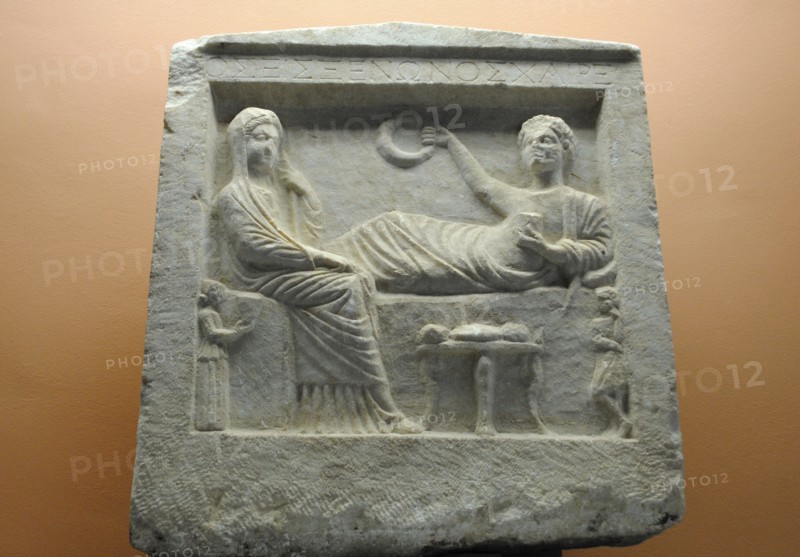 Tombstone. 'Parting scene' in relief.