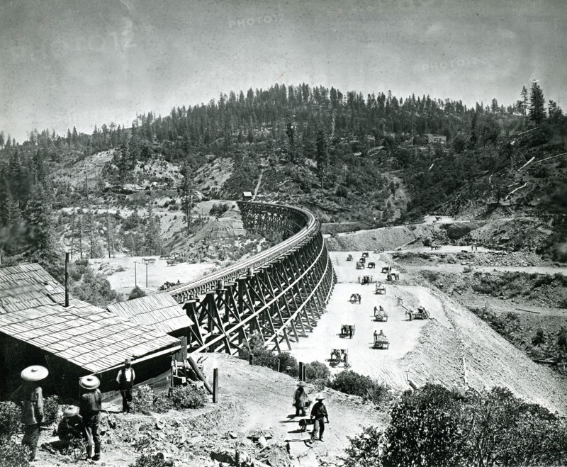 1877 - In its eagerness to push toward Utah in its race with the westward building Union Pacific, Central Pacific Railroad bridged many of the High Sierra chasms with timber trestles. This remarkable photo was taken at Secrettown Trestle, 62 miles from Sacramento on the western slope of the Sierras in 1877.