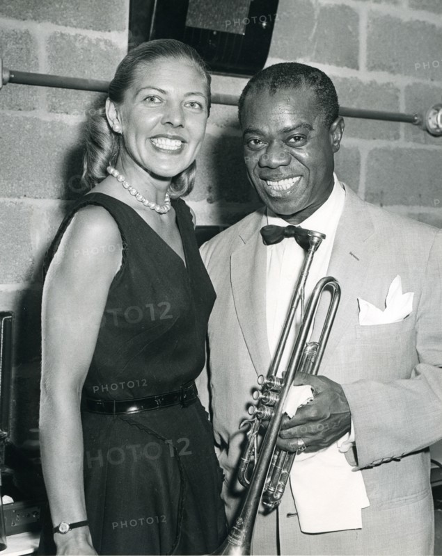 Louis 'Satchmo' Armstrong plays his trumpet in front of a Voice of American microphone. Armstrong is a leading good will ambassador through his music. Washington, DC, 1960.