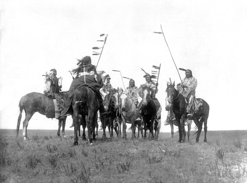 Edward S. Curtis Native American Indians - Several Atsina warriors on horseback some with feathered staffs and one with a headdress circa 1908.