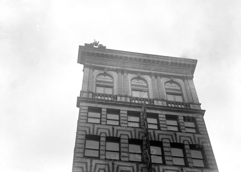 J. Reynolds Acrobat, performing acrobatic and balancing acts on top of building above 9th Street NW in Washington D.C. circa 1917.