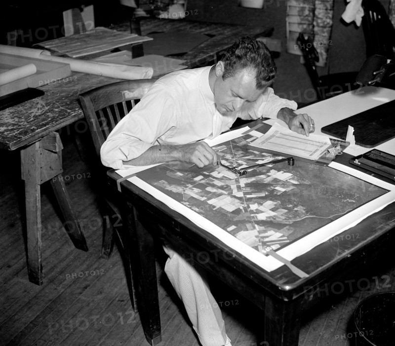 A worker using a planimetor, which measures the exact acreage in each section of land surface photographed circa 1937.