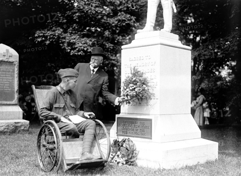 Wounded soldier in wheelchair visits monument at Alrington National Cemetery circa 1919 .