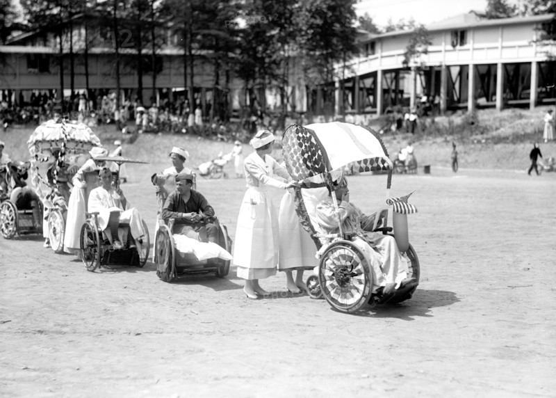 Wounded WW I soldiers at Walter Reed Hospital participate in a 4th of July wheel chair parade circa 1919 .