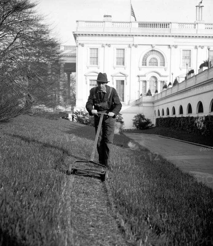 White House gardener at the Executive Mansion, is mowing the lawn today circa 1937.