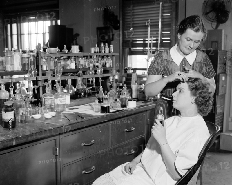 Testing cosmetics for the government. Washington D.C. July 10- Mrs. R. Goodman, is shown sitting with Mrs. C.R. West applying dye for the hair, some dyes contain lead and the poison in the dye may lead to chronic poisoning circa 1937.