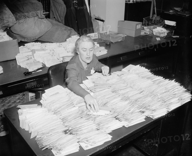 January 28, 1938 - Miss Margaret Lehand, Personal Secretary to President Roosevelt, is shown opening some of the 30,000 letters with donated dimes to the infantile paralysis foundation to arrive in the mail .