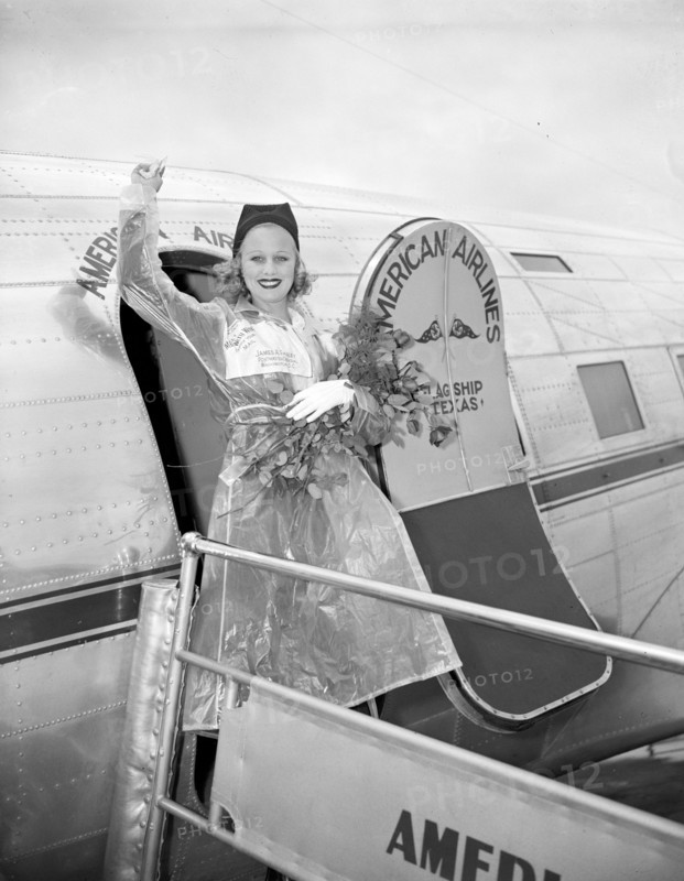 Miss Marion Weldon, Paramount starlet, waves a greeting to the throng as she arrived at Washington Airport today to participate in National Airmail Week circa 1938.