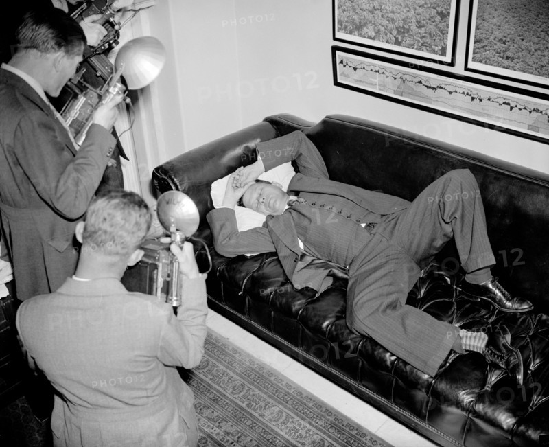 Senator Allen Ellender Democrat of Louisana and onetime Lieutenant of the late Huey Long, is snapped by news cameramen as he rests in his office  circa 1938.