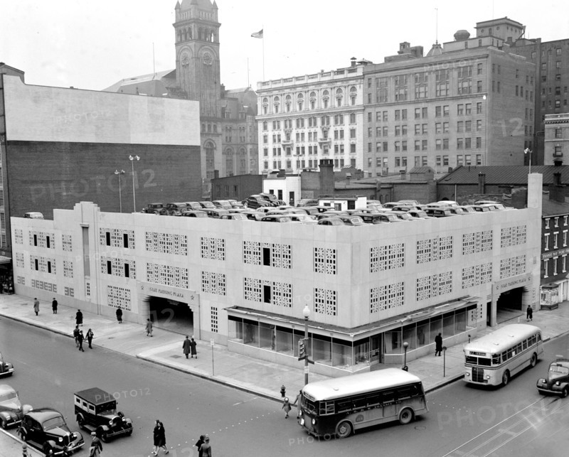 Street scene with buses, cars and pedestrians outside Star Parking Plaza in Washington D.C. circa 1940 .