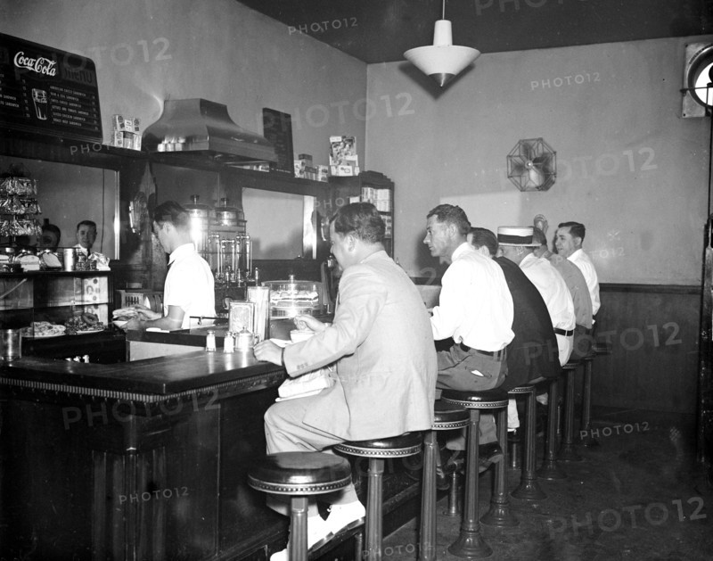 Men eating at lunch counter of restaurant inside Greyhound Bus Terminal circa 1936 or 1937.