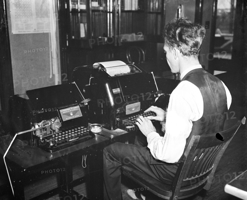 Worker operating a new radio teletypewriter service which allows for instantaneous transmission of written records without the aid of wires, has been perfected by the experts of the Bureau of Air Commerce circa 1936.