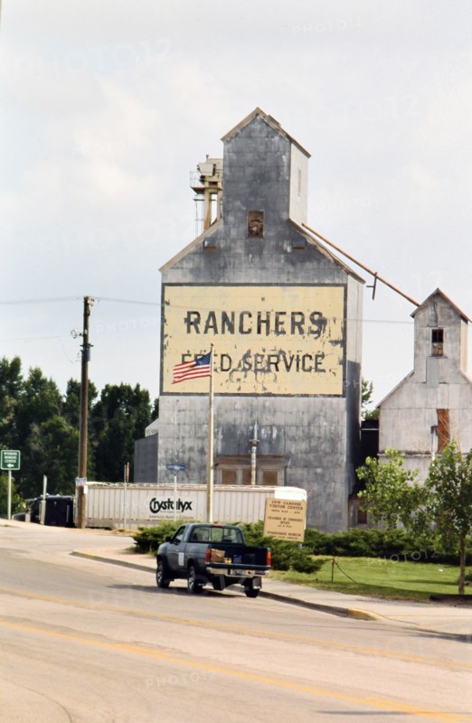 July 2001 - Pick up truck on highway through downtown Lusk Wyoming  - Rancher's Feed Service Silo.