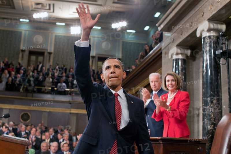President Barack Obama waves to the First Lady and guests seated in the gallery of the House Chamber at the U.S. Capitol in Washington, D.C., Sept. 9, 2009. IN the background are Vice President Joe Biden and Speaker of the House Nancy Pelosi..