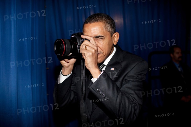 President Barack Obama takes aim with a photographer's camera backstage prior to remarks about providing mortgage payment relief for responsible homeowners. Dobson High School. Mesa, Arizona 2/18/09.  .