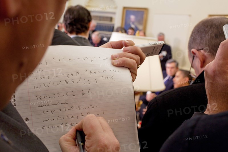 A reporter takes notes while President  Barack Obama and Prime Minister Gordon Brown of the United Kingdom speak to the press in the  Oval Office 3/3/09. .