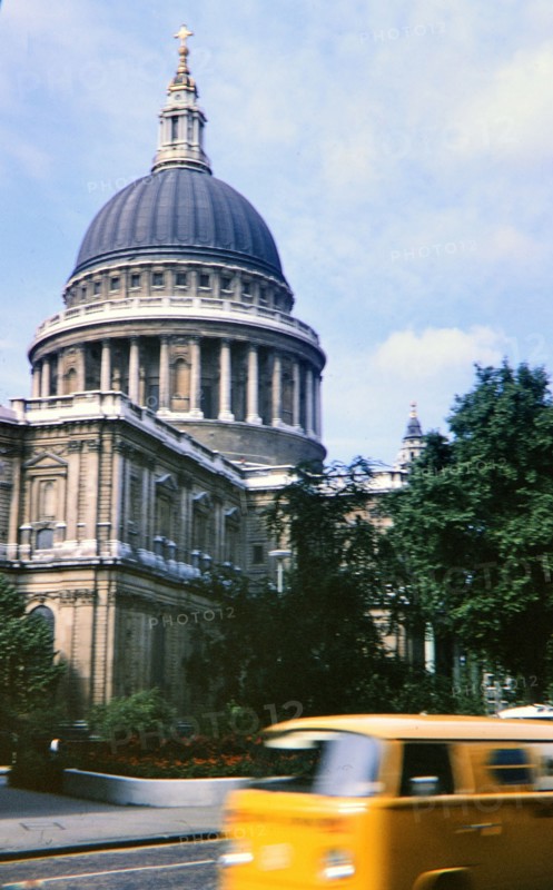 Yellow Van driving by unidentified building in UK circa 1973.