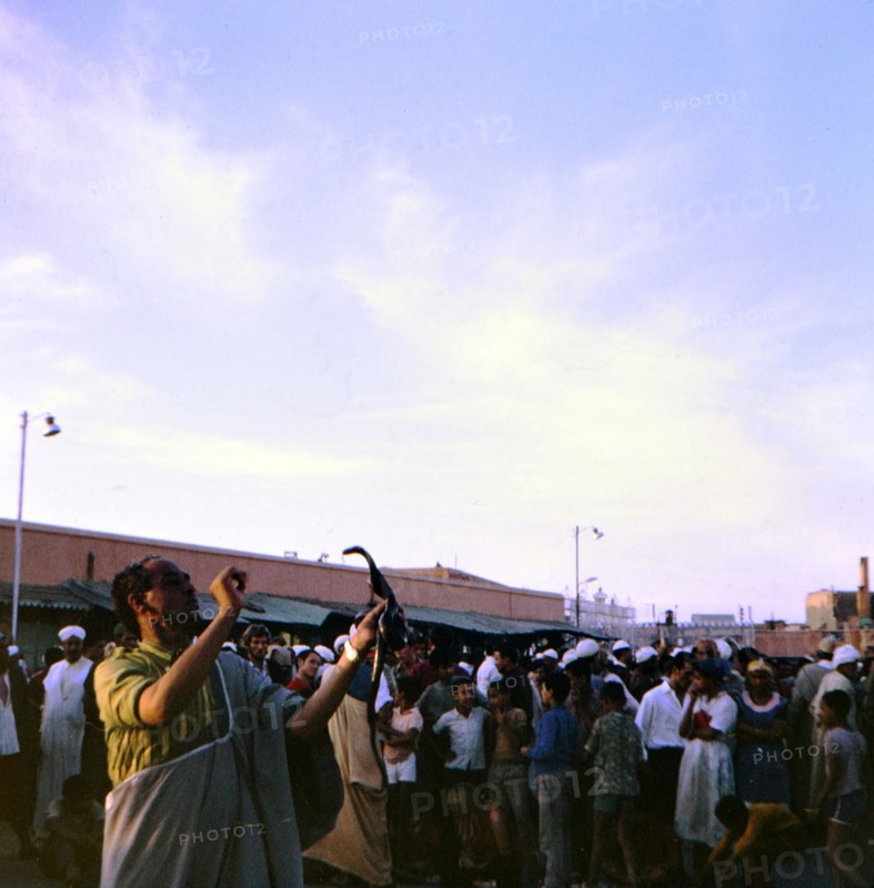 Snake charmer holding a snake in the marketplace in Marrakesh Morocco circa 1969.