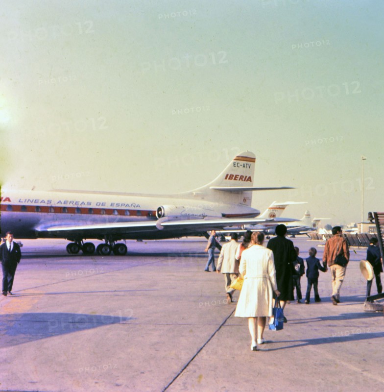 Airplane passengers walking on the tarmac at the Madrid Spain airport before boarding a plane circa 1969.