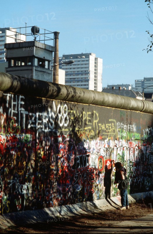 A West German child attempts to chip off a piece of the Berlin Wall as a souvenir.   .