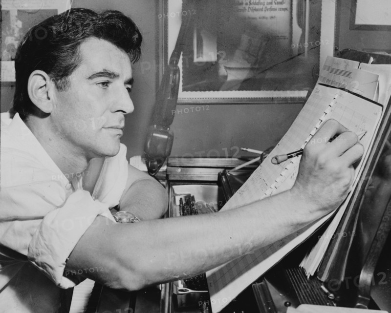 American conductor Leonard Bernstein writing music