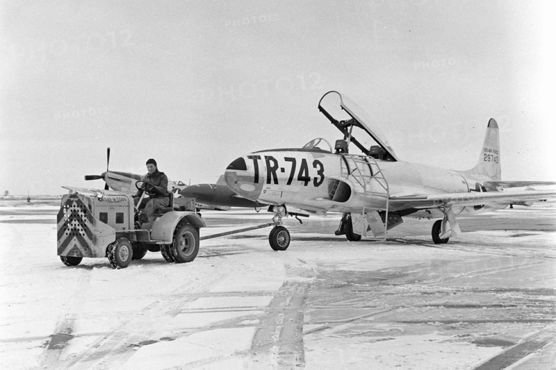A T-33 aircraft is towed on the flight line
