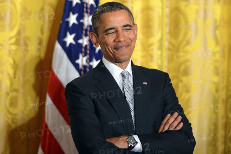 President Barack Obama smiles as first lady Michelle Obama speaks