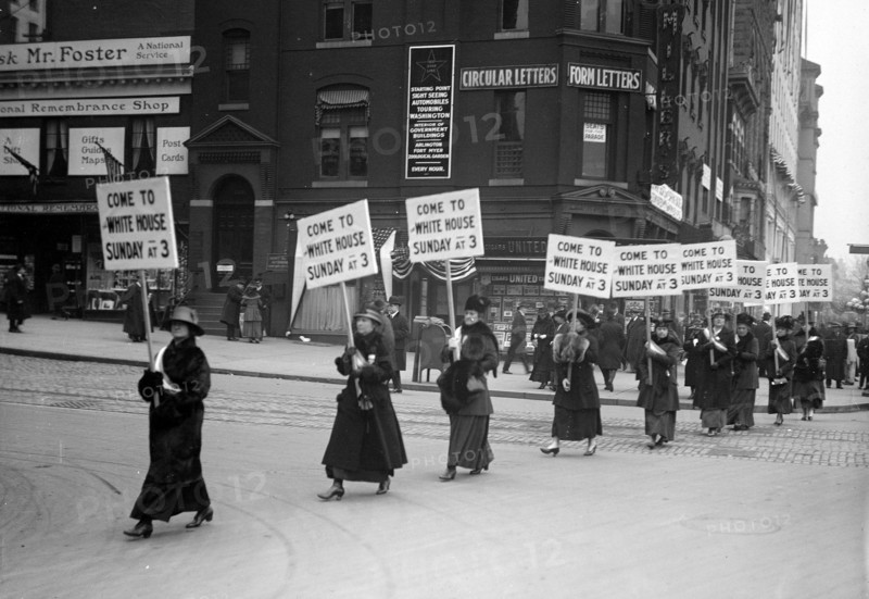 Woman suffragettes marching through the streets