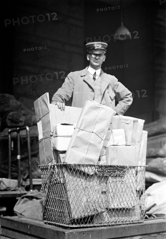 Mail man with a basket full of parcel post packages
