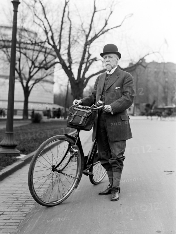 Old man standing next to his bicycle