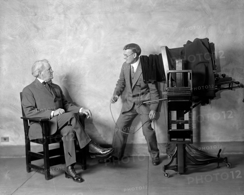 Cliff Berryman being posed for a portrait at the Harris & Ewing Studio